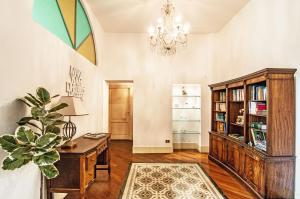 ein Heimbüro mit einem Holzschreibtisch und einem Kronleuchter in der Unterkunft Dream House in Bergamo
