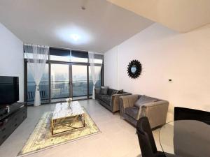 a living room with a couch and a tv at SeaView Inn in Abu Dhabi