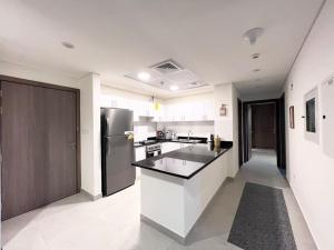 Il comprend une cuisine blanche équipée d'un réfrigérateur et d'un comptoir. dans l'établissement SeaView Inn, à Abu Dhabi
