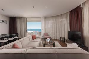 فندق ومنتجع Dukley في بودفا: غرفة معيشة مع أريكة بيضاء كبيرة وتلفزيون