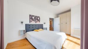 ein Schlafzimmer mit einem großen weißen Bett in einem Zimmer in der Unterkunft Apartamenty Sun & Snow Przy plaży in Mielno