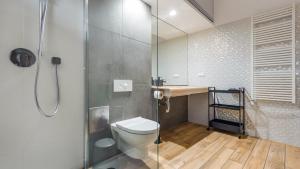 ein Bad mit einem WC und einer Glasdusche in der Unterkunft Apartamenty Sun & Snow Przy plaży in Mielno