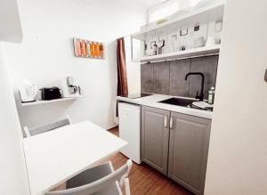 uma pequena cozinha com um lavatório e uma mesa em Linden Apartment Wolfenbüttel em Volfembutel