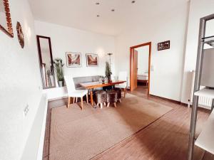 a living room with a dining room table and chairs at Linden Apartment Wolfenbüttel mit Ladestation für E-Auto in Wolfenbüttel