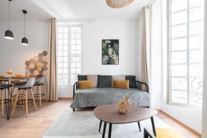 a living room with a bed and a table at Les Petits Pavillons Appartements Standing 1 chambre 4 pers Clim Vieux-Port in Marseille