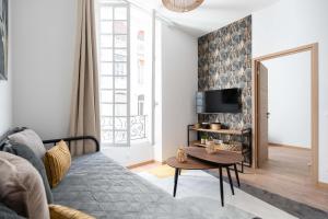 un soggiorno con divano e tavolo di Les Petits Pavillons Standing Clim Vieux-Port - MaisonMars a Marsiglia