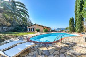 una piscina con due sedie e una casa di Elba Offsite Villa a Capoliveri