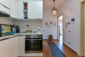 una cucina con mobili bianchi e una stufa di Elba Offsite Villa a Capoliveri