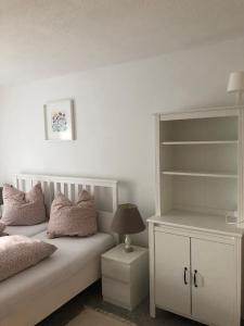 a bedroom with a white bed with pillows and a lamp at Ferienwohnung Villa Hygge in Mitterteich