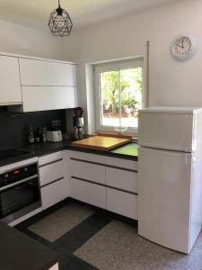 een keuken met witte apparatuur en een raam bij Ferienwohnung Villa Hygge in Mitterteich