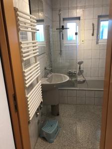 een witte badkamer met een wastafel en een bad bij Ferienwohnung Villa Hygge in Mitterteich