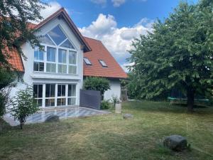 a white house with a bench in a yard at Ferienwohnung Villa Hygge in Mitterteich