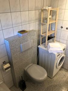 een kleine badkamer met een toilet en een plank bij Ferienwohnung Villa Hygge in Mitterteich