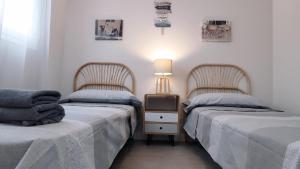 two beds sitting next to each other in a room at Dunas Beach II Apartment in Torrox Costa