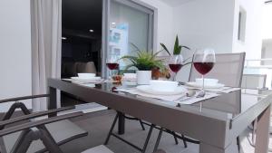 a dining room table with glasses of red wine at Dunas Beach II Apartment in Torrox Costa +21 photos
