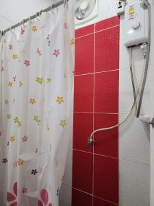 a shower curtain with flowers on it in a bathroom at Psm at Donmueng in Ban Don Muang (1)