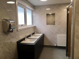 La salle de bains est pourvue de 3 lavabos et d'une fenêtre. dans l'établissement Great Glen Hostel, à Spean Bridge