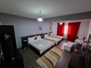 泰托沃的住宿－Hotel Yal Restaurant，一间卧室设有两张床和红色窗帘