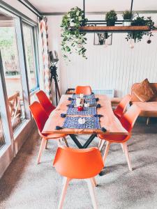 a table with orange chairs in a room at Wooden Cosy Retreat Hunters Quay in Dunoon