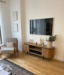 Televízia a/alebo spoločenská miestnosť v ubytovaní Appartement Le Palais du Commerce