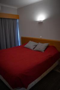 a bedroom with a red bed with a window at ApartPatos Luxury Home in Portimão