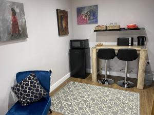 a living room with a blue chair and a table at Bracken Lodge in Brighouse