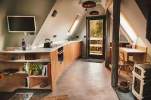 uma cozinha com um lavatório e uma mesa num quarto em Skapya Treehouse with private hot tub . em Helston