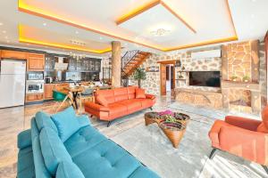 a living room with orange furniture and a kitchen at Patara'da 3 Yatak Odalı Deniz Manzaralı Lüks Villa in Gelemiş