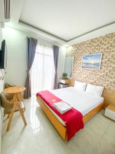 a bedroom with a bed and a chair and a window at Lộc Thiên Ân hotel in Bien Hoa