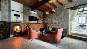 a living room with a fireplace and pink chairs at Sulty's Alaçatı in Izmir