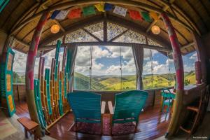 a room with a large window with chairs and skis at Chalés Grande Vista - Difícil não se maravilhar! in Cunha