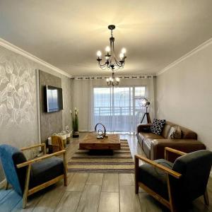 een woonkamer met een bank en een tafel bij Luxurious 2-bedroom beach apartment with a view! in Bloubergstrand