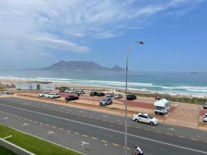 a highway with cars parked next to the beach at Luxurious 2-bedroom beach apartment with a view! in Bloubergstrand