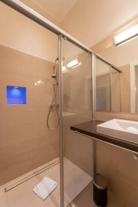 a bathroom with a glass shower and a sink at Levestate Apartments Klährgasse Vol 4 in Vienna