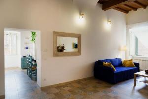 uma sala de estar com um sofá azul e um espelho em Casa Gli Olmi - centro storico em Bracciano