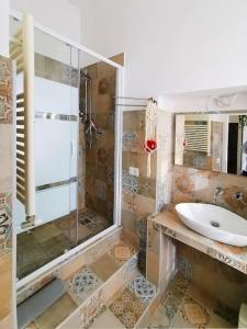 uma casa de banho com uma cabina de duche em vidro e um lavatório. em Casa Gli Olmi - centro storico em Bracciano