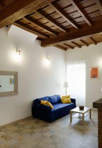 uma sala de estar com um sofá azul e uma mesa em Casa Gli Olmi - centro storico em Bracciano