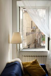 uma sala de estar com um sofá e uma janela em Casa Gli Olmi - centro storico em Bracciano