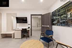 Cette chambre dispose d'une table, de chaises et d'un bureau. dans l'établissement Modern, Large and Spacious HOME, Perfect for GROUP by 360 Estates, à Msida