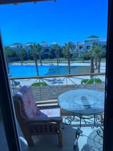 einen Balkon mit einem Tisch und Poolblick in der Unterkunft Palm resort 2B in Sharm El Sheikh