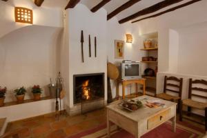a living room with a fireplace and a table at Casa rural Plaza Vieja en Bullas in Bullas