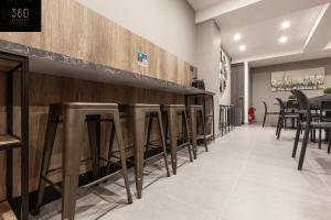une rangée de tabourets de bar dans un restaurant dans l'établissement Modern, Large and Spacious HOME, Perfect for GROUP by 360 Estates, à Msida
