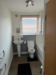 La salle de bains est pourvue de toilettes blanches et d'un lavabo. dans l'établissement Ferry Gait, à Édimbourg