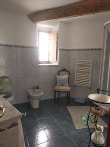 łazienka z toaletą, oknem i krzesłem w obiekcie APPARTAMENTO INCANTEVOLE CON GIARDINO w Genui