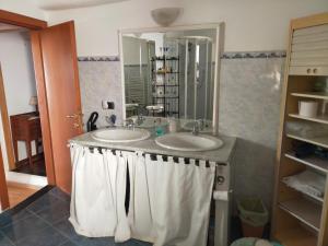 Baño con 2 lavabos y espejo en APPARTAMENTO INCANTEVOLE CON GIARDINO, en Génova