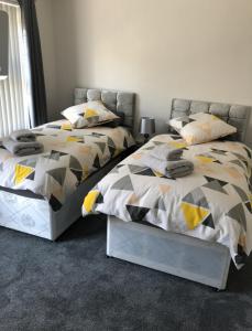 dos camas sentadas una al lado de la otra en un dormitorio en 2 Bedroom Luton Townhouse, en Luton