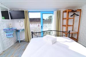 a bedroom with a white bed and a window at Sulty's Alaçatı in Izmir