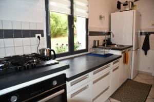 a kitchen with a stove and a sink and a refrigerator at Maison Marguerite in Bordères-Louron