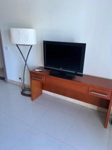TV de pantalla plana sobre una mesa de madera en Palm resort 2B en Sharm El Sheikh