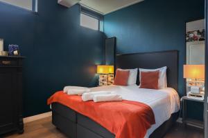 a bedroom with a large bed with blue walls at ZEEenMEER in Kamperland